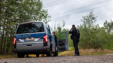 Polizeikräfte stehen in einem Waldstück unter einer Stromtrasse nahe dem Ort Schleife im Landkreis Görlitz, Sachsen, am 04.09.2026.