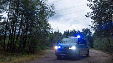 Polizeikräfte stehen in einem Waldstück unter einer Stromtrasse nahe dem Ort Schleife im Landkreis Görlitz, Sachsen, am 04.09.2026.