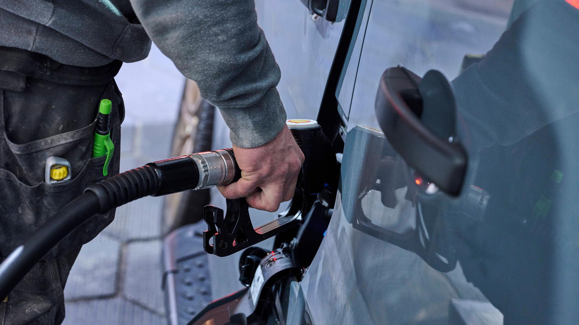 Mann an der Zapfsäule betankt sein Auto.