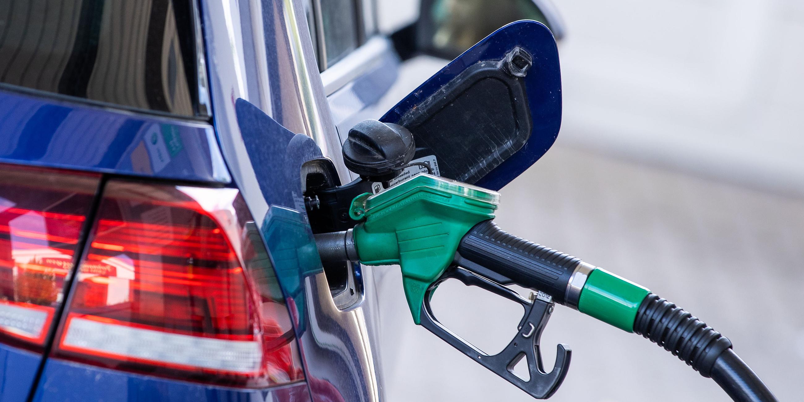 Die Zapfpistole für Super-Kraftstoff steckt in einer Tankstelle im Tankstutzen eines Autos