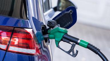 Die Zapfpistole für Super-Kraftstoff steckt in einer Tankstelle im Tankstutzen eines Autos