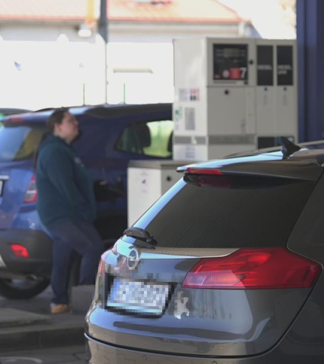 Menschen beim Tanken an der Tankstelle
