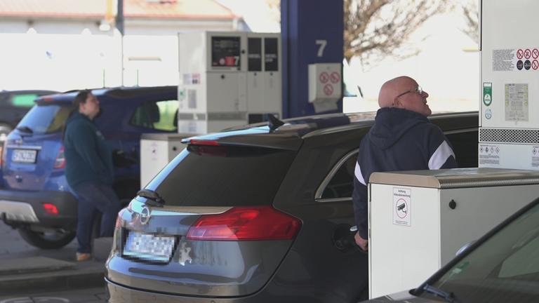 Menschen beim Tanken an der Tankstelle