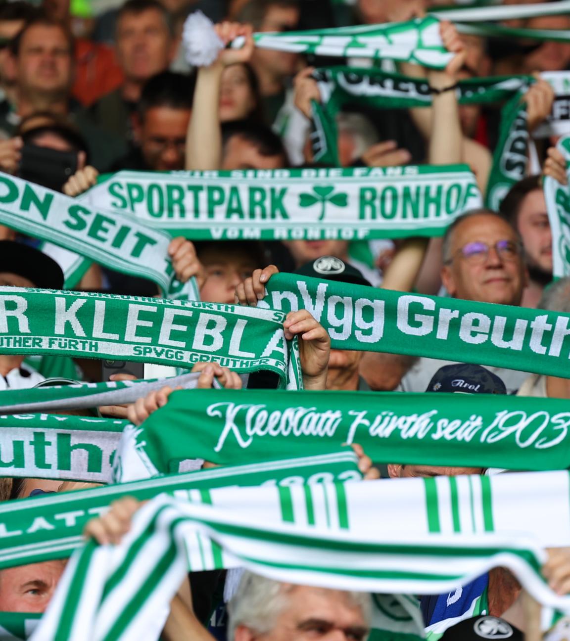 Es sind Fans mit Schals des SpVgg Greuther Fürth zu sehen.