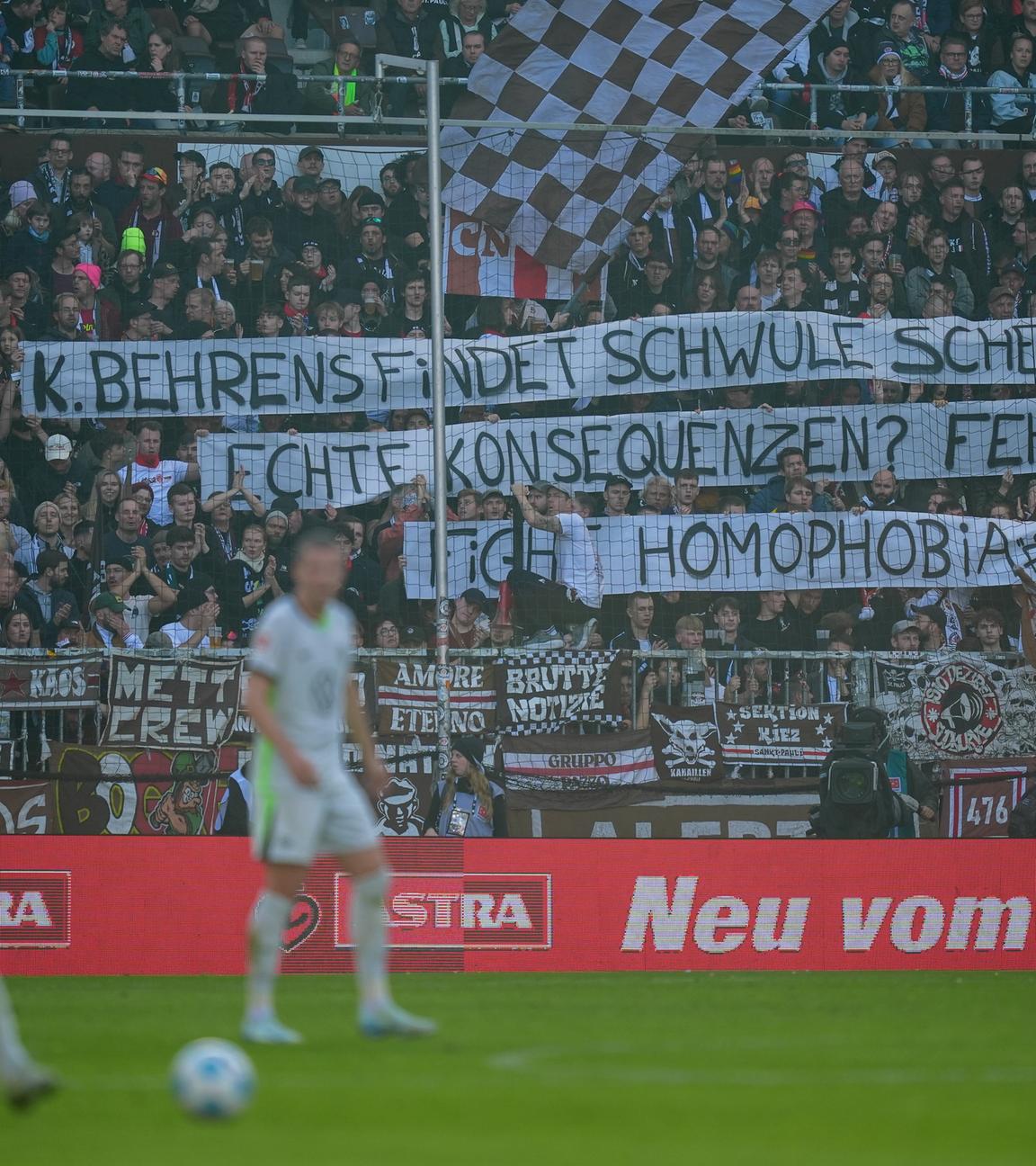 Fans halten Plakate nach den homophoben Aussagen des Wolfsburger Stürmers Kevin Behrens hoch. 