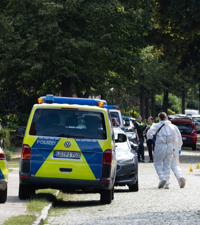 Beamte der Spurensicherung auf der Straße vor dem Tatort.