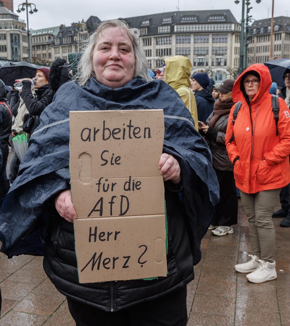 Eine Frau hält auf der Demonstration unter dem Motto «Wir sind das Stadtbild» ein Schild mit der Aufschrift «Arbeiten Sie für die AfD Herr Merz?».
