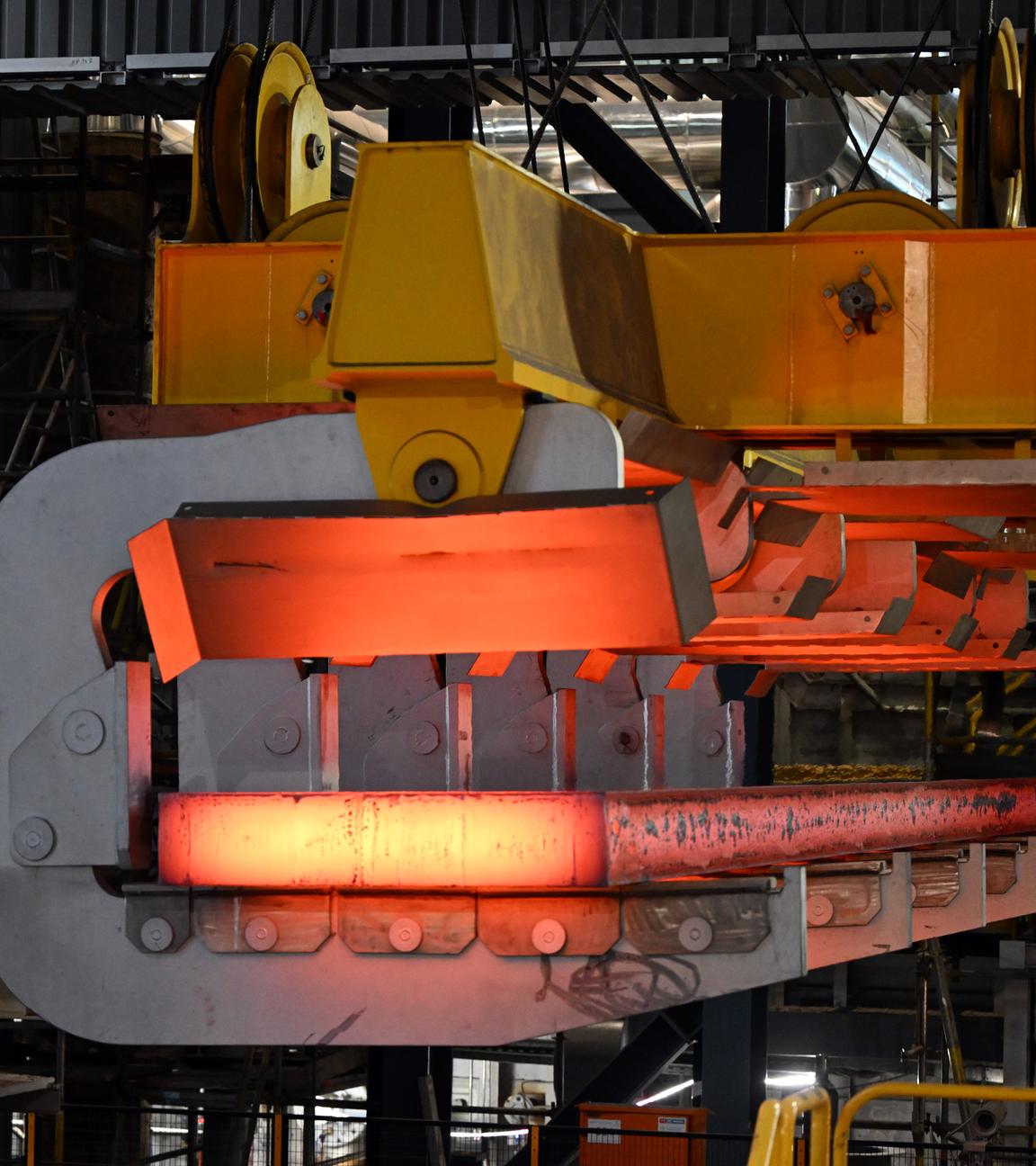 Eine glühende Bramme wird mit einem Kran aus der Stranggießanlage bei Thyssenkrupp Steel transportiert. 