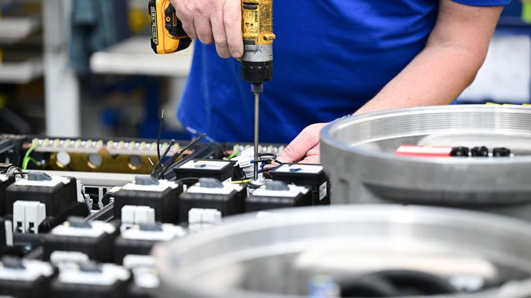 Arbeiter in einer Produktionshalle für Schaltanlagen