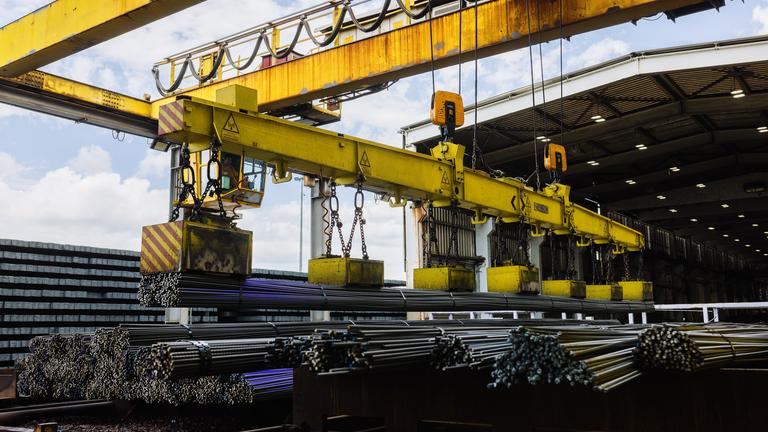 Ein Kran im Stahlwerk in Kehl tranportiert frisch gewalzten Armierungsstahl.