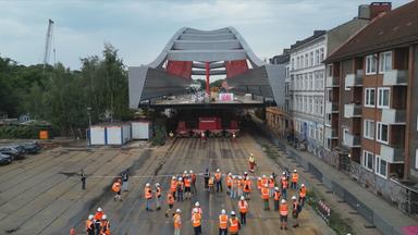 Ein Teil der Eisenbahnbrücke wird durch ein Wohnviertel in Hamburg transportiert.