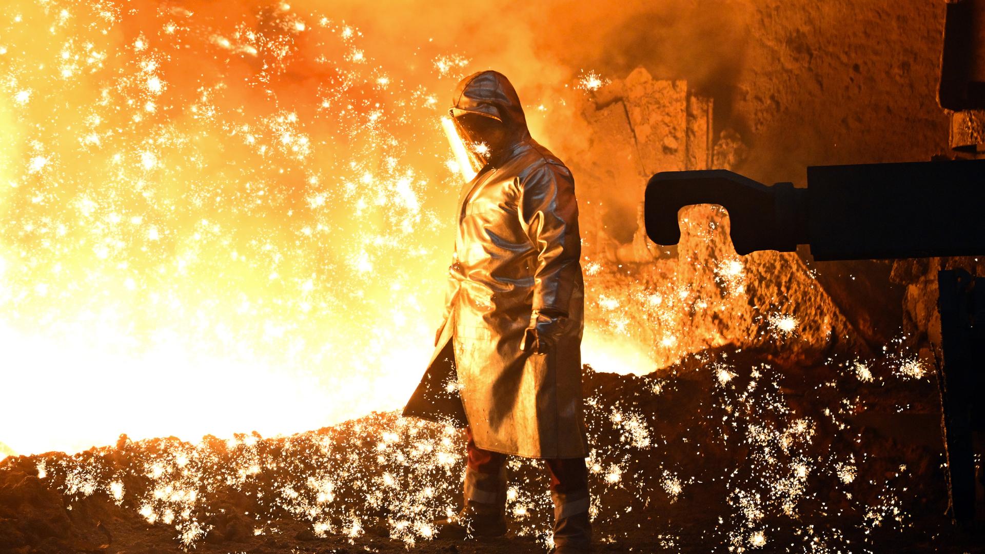 Nordrhein-Westfalen, Duisburg: Ein Mitarbeiter steht an einem Hochofen. Archivbild