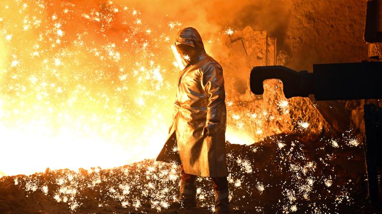 Nordrhein-Westfalen, Duisburg: Ein Mitarbeiter steht an einem Hochofen. Archivbild