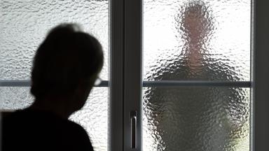 Stalker hinter einer Glasscheibe