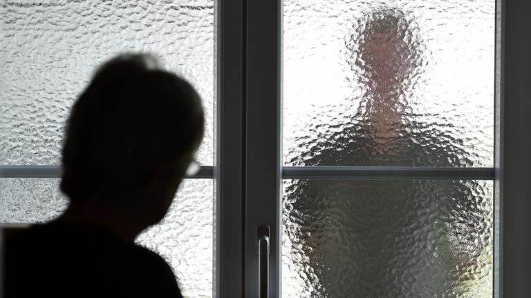 Stalker hinter einer Glasscheibe