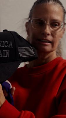 Eine Frau hält eine Kappe mit der Aufschrift "Make America great again"