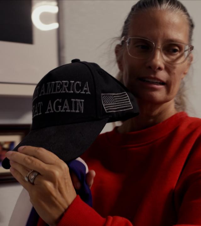Eine Frau hält eine Kappe mit der Aufschrift "Make America great again"