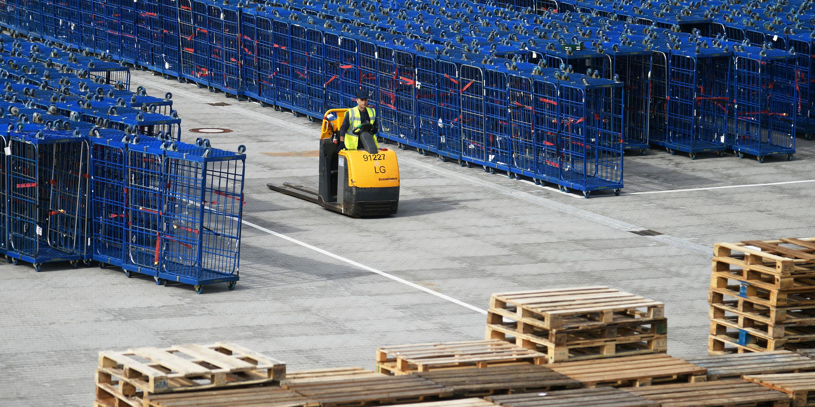 Ein Staplerfahrer ist am Dienstag, 21.09.2021 inmitten von Versandboxen auf dem Gelände eines Logistikzentrums unterwegs.