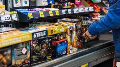  An der Kasse eines Supermarktes legt ein Kunde Feuerwerk auf das Kassenband.