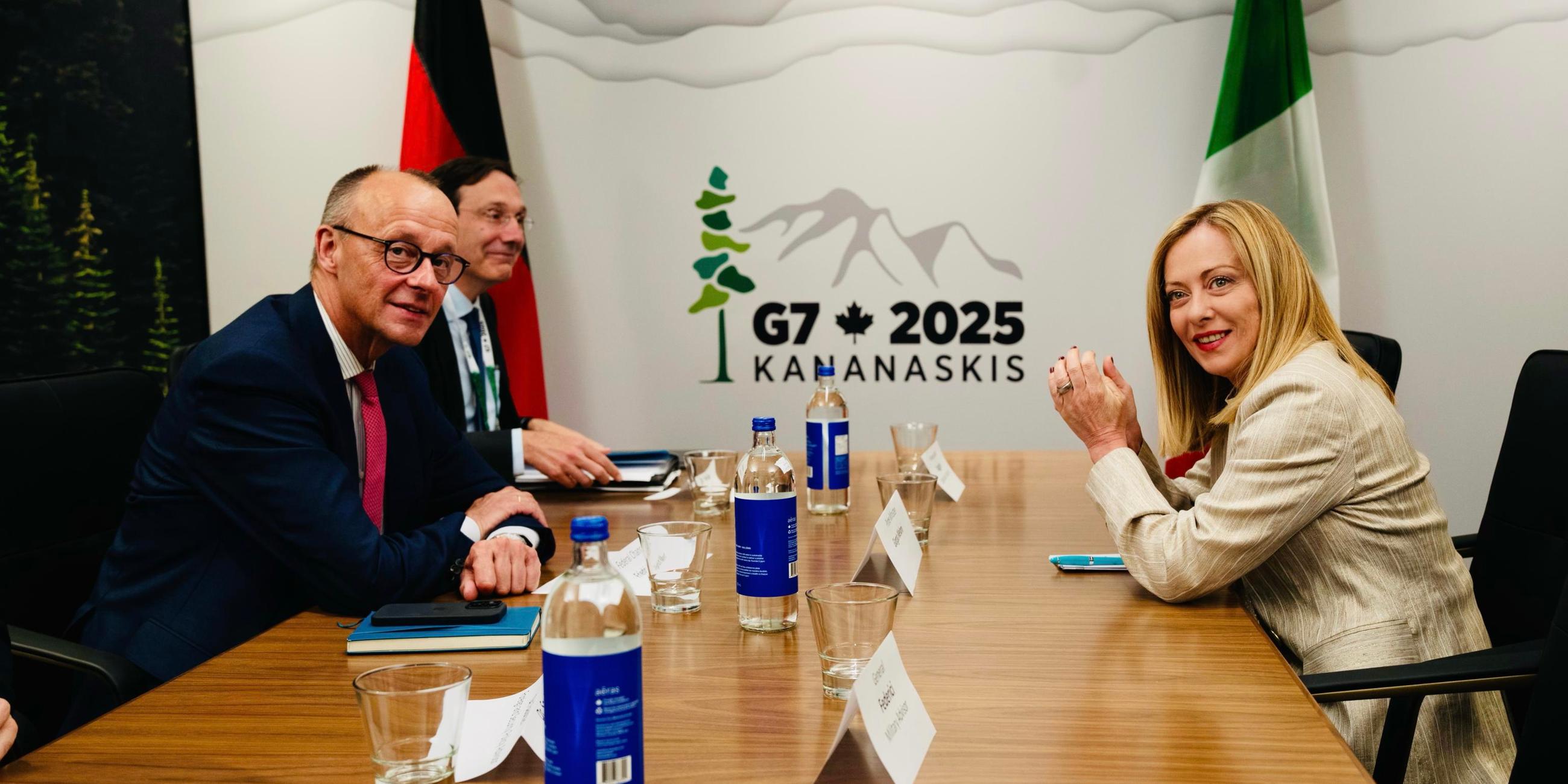 Die italienische Premierministerin Giorgia Meloni und Friedrich Merz sitzen an einem Tisch bei dem g7-Gipfeltreffen