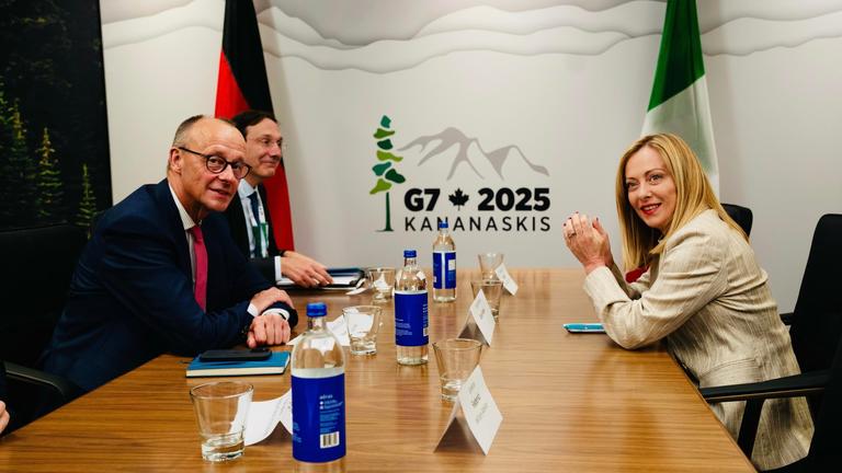Die italienische Premierministerin Giorgia Meloni und Friedrich Merz sitzen an einem Tisch bei dem g7-Gipfeltreffen