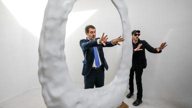 Italiens stellvertretender Ministerpräsident Matteo Salvini (l) besucht den Pavillon der Vereinigten Staaten. Es ist ein weißer Raum mit einer weißen ovalförmigen Skulptur.