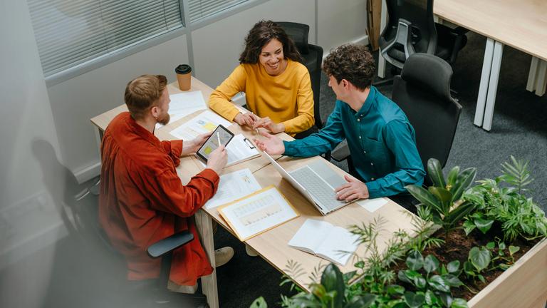 Illustration: Junge Kollegen diskutieren Geschäftsstrategien in einem modernen Büroumfeld