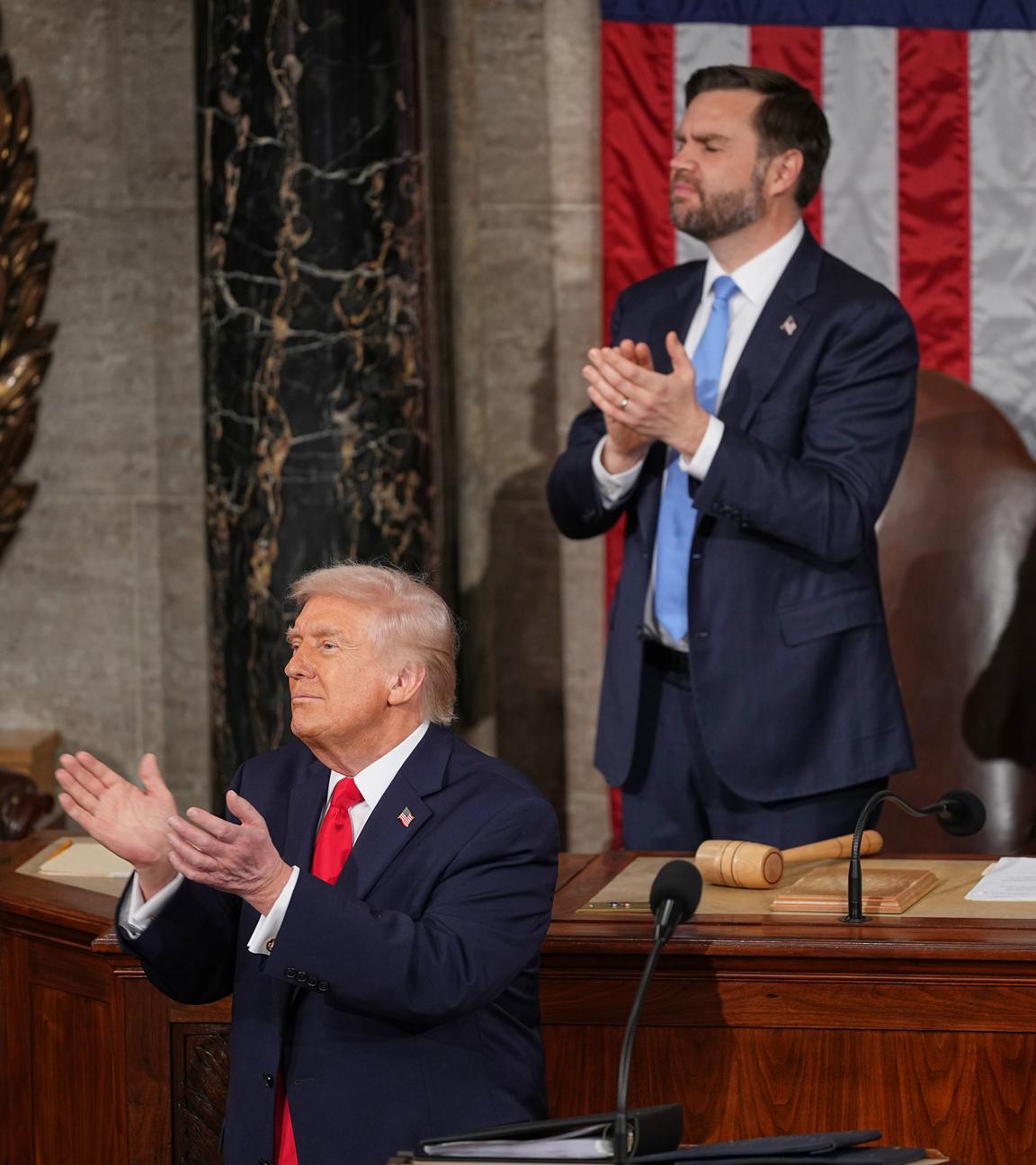 Präsident Trump applaudiert zusammen mit Vizepräsident Vance und dem Sprecher des Repräsentantenhauses Mike Johnson, während er eine Rede hält.
