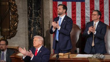 Präsident Trump applaudiert zusammen mit Vizepräsident Vance und dem Sprecher des Repräsentantenhauses Mike Johnson, während er eine Rede hält.