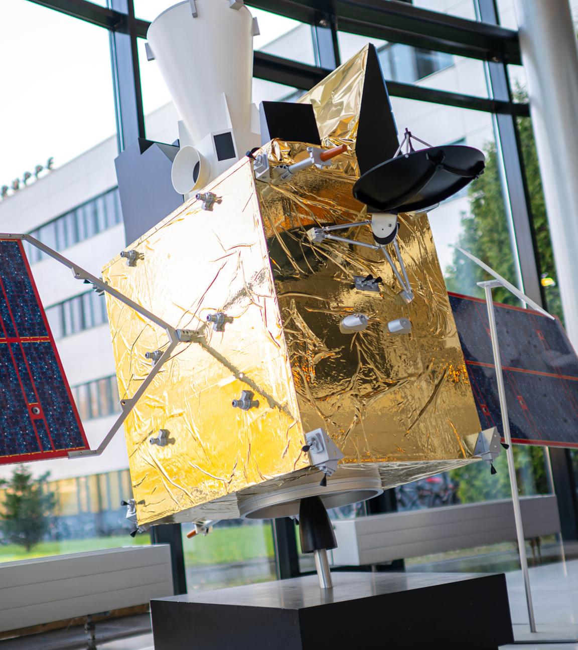 Modelle von Satelliten stehen im Firmengebäude des Raumfahrt- und Technologiekonzerns OHB. 