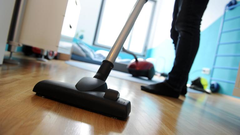 Jemand saugt mit dem Staubsauger eine Wohnung