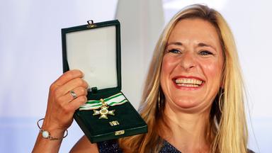 Stefanie Hertel hält ihren Verdienstorden hoch