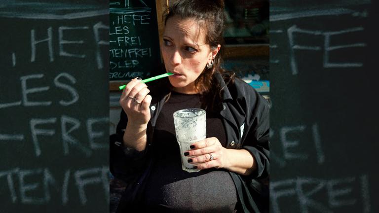 Silbermond-Sängerin Stefanie Kloß mit Baby-Bauch und einem leeren Glas in der Hand.