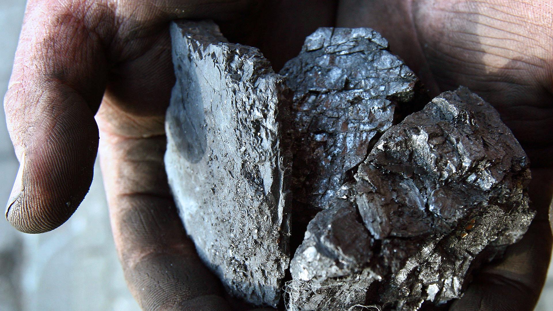 Archiv: Ein Mann hält Kohlestücke in den Händen
