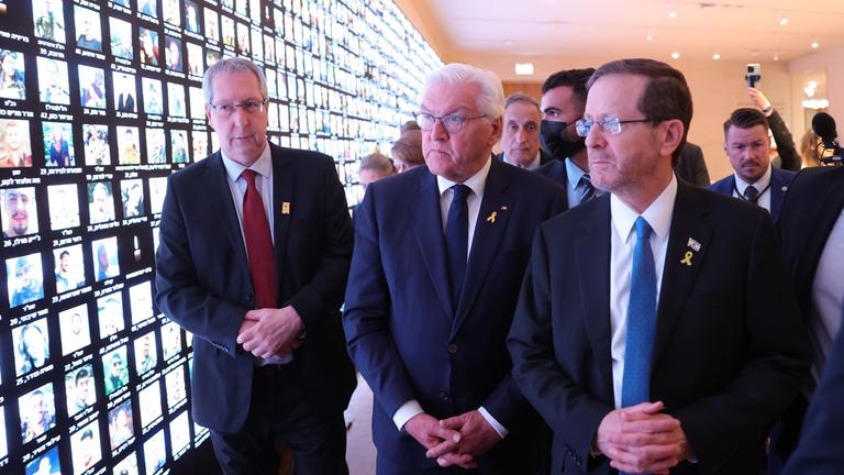 Der israelische Präsident Isaac Herzog und der deutsche Präsident Frank-Walter Steinmeier betrachten bei einem Besuch der Nationalbibliothek Israels in Jerusalem einen Bildschirm mit Bildern israelischer Opfer der Anschläge vom 7. Oktober.
