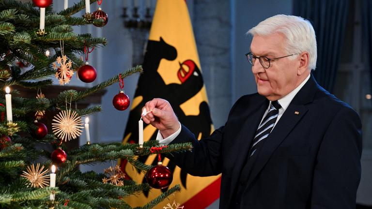 Bundespräsident Steinmeier neben einem Weihnachtsbaum im Schloss Bellevue.