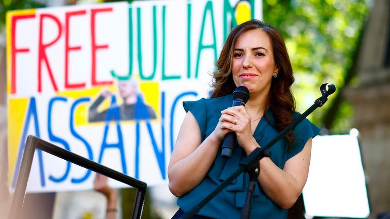 Eine Frau mit einem Mikro in der Hand auf einer Demonstration.