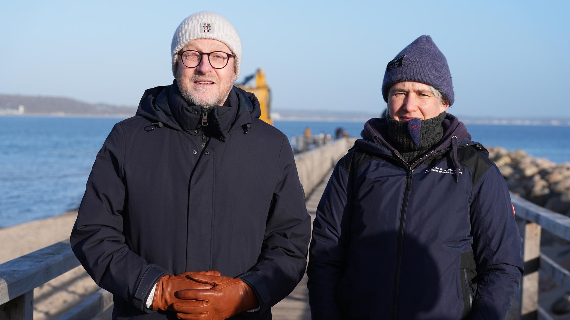 Stephanie Groß (r), Institut für Terrestrische und Aquatische Wildtierforschung (ITAW), und Sven Partheil-Böhnke, Bürgermeister von Timmendorfer Strand, stehen am 27.03.2026 auf der Seebrücke am Hafen von Niendorf.