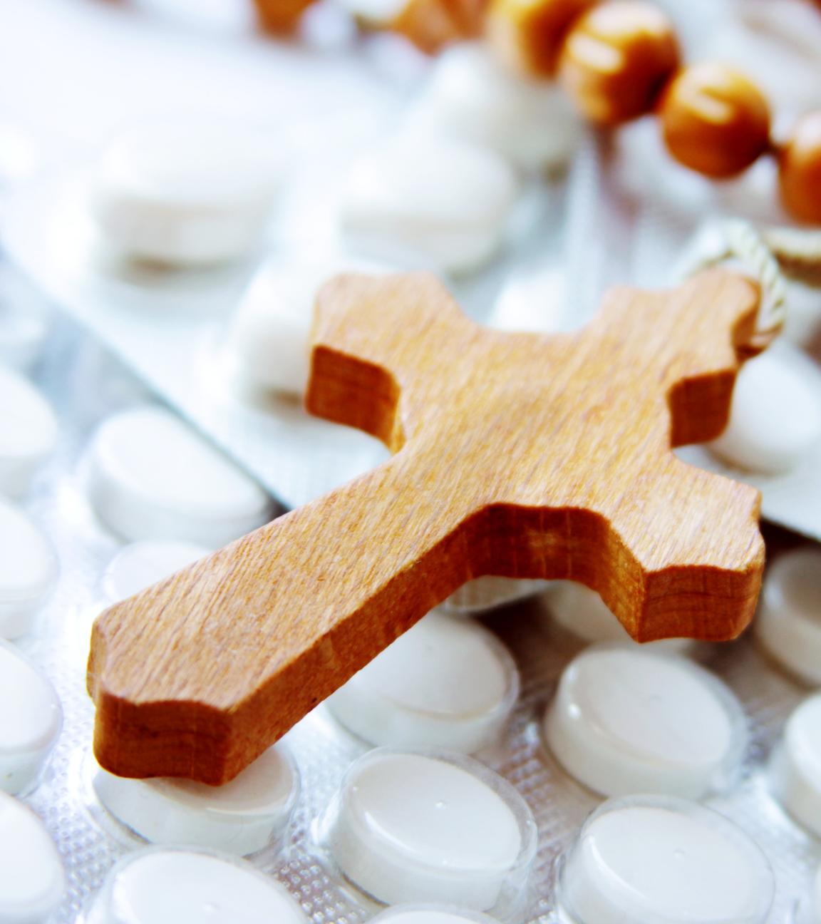 Ein hölzerner Rosenkranz auf Tabletten.