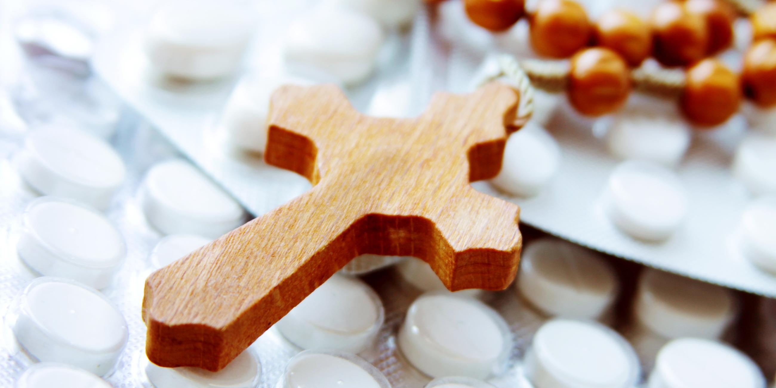 Ein hölzerner Rosenkranz auf Tabletten.