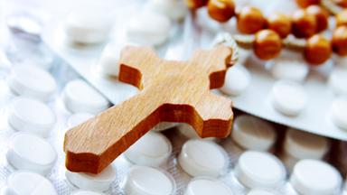 Ein hölzerner Rosenkranz auf Tabletten.
