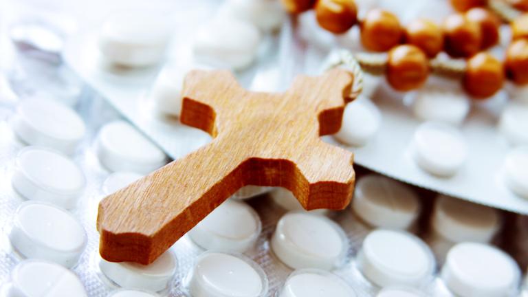 Ein hölzerner Rosenkranz auf Tabletten.