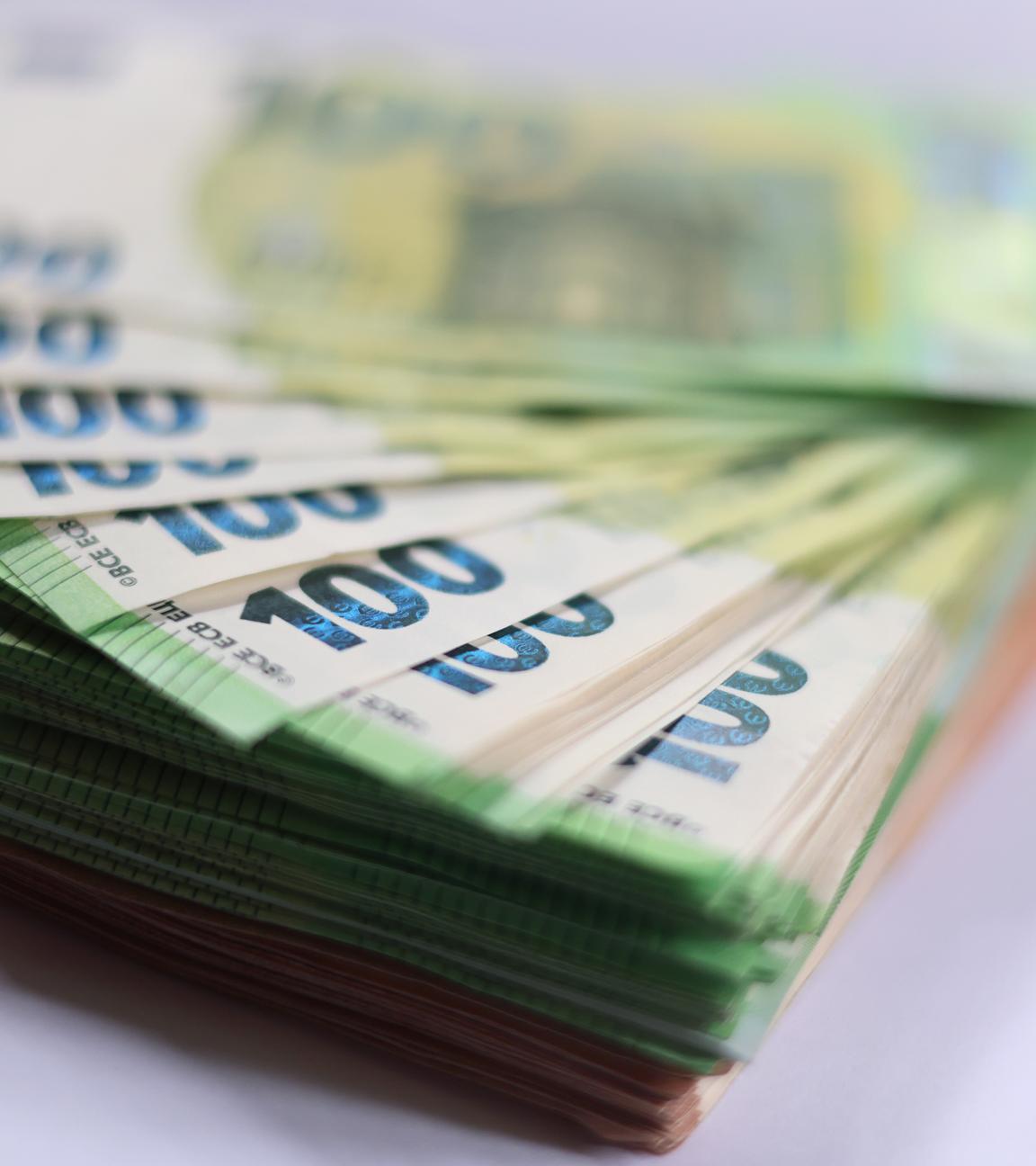 100-Euro-Banknoten liegen auf einem Tisch. 
