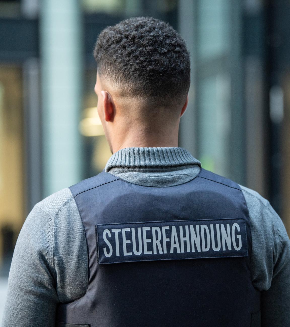 Ein Bediensteter der Steuerfahndung trägt im Rahmen eines Pressetermins am 15.01.2020 in Frankfurt am Main eine Schutzweste mit der Aufschrift "Steuerfahndung".