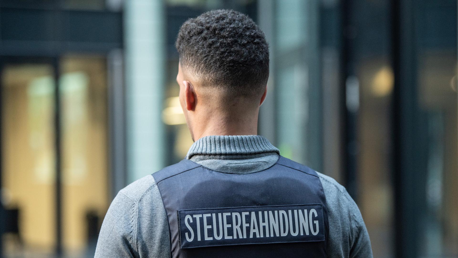 Ein Bediensteter der Steuerfahndung trägt im Rahmen eines Pressetermins am 15.01.2020 in Frankfurt am Main eine Schutzweste mit der Aufschrift "Steuerfahndung".