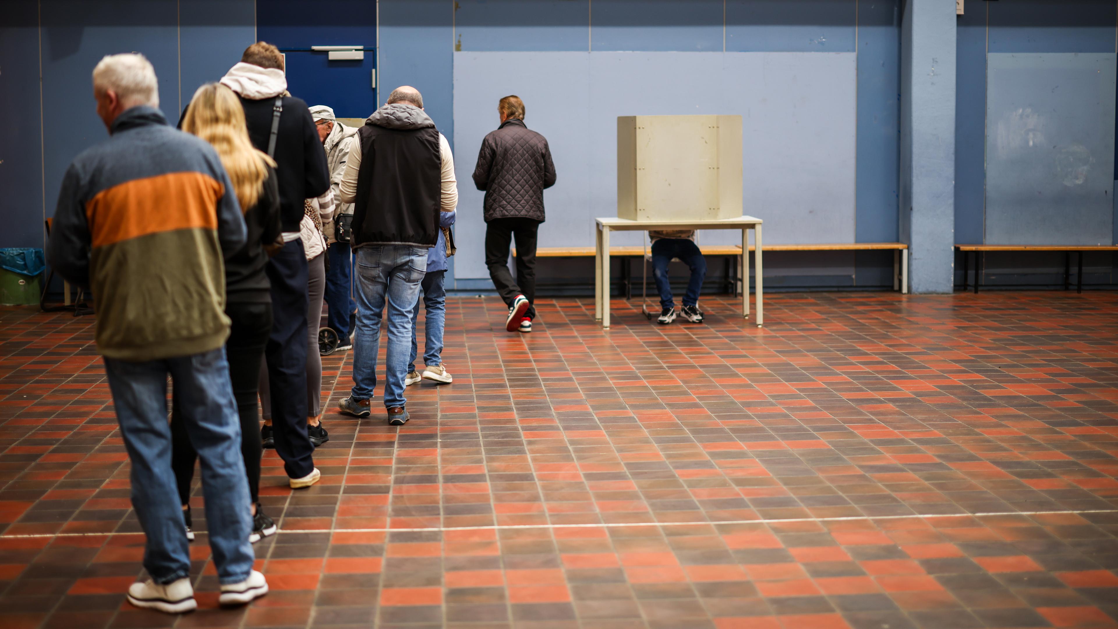 In einem Wahllokal in Duisburg-Neumühl stehen Menschen und warten auf eine freie Wahlkabine am 14.09.2025 in Duisburg, Nordrhein-Westfalen.
