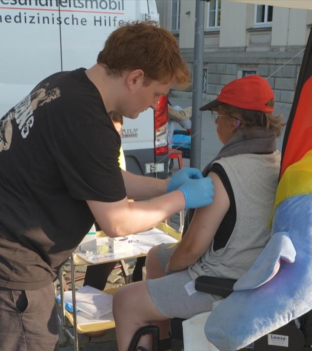 Ein Mensch wird von einem freiwilligen geimpft.