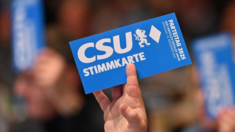 Eine Hand hält eine Stimmkarte während des Parteitags der Christlich-Sozialen Union (CSU) am 12.12.2025 in München, hoch. 