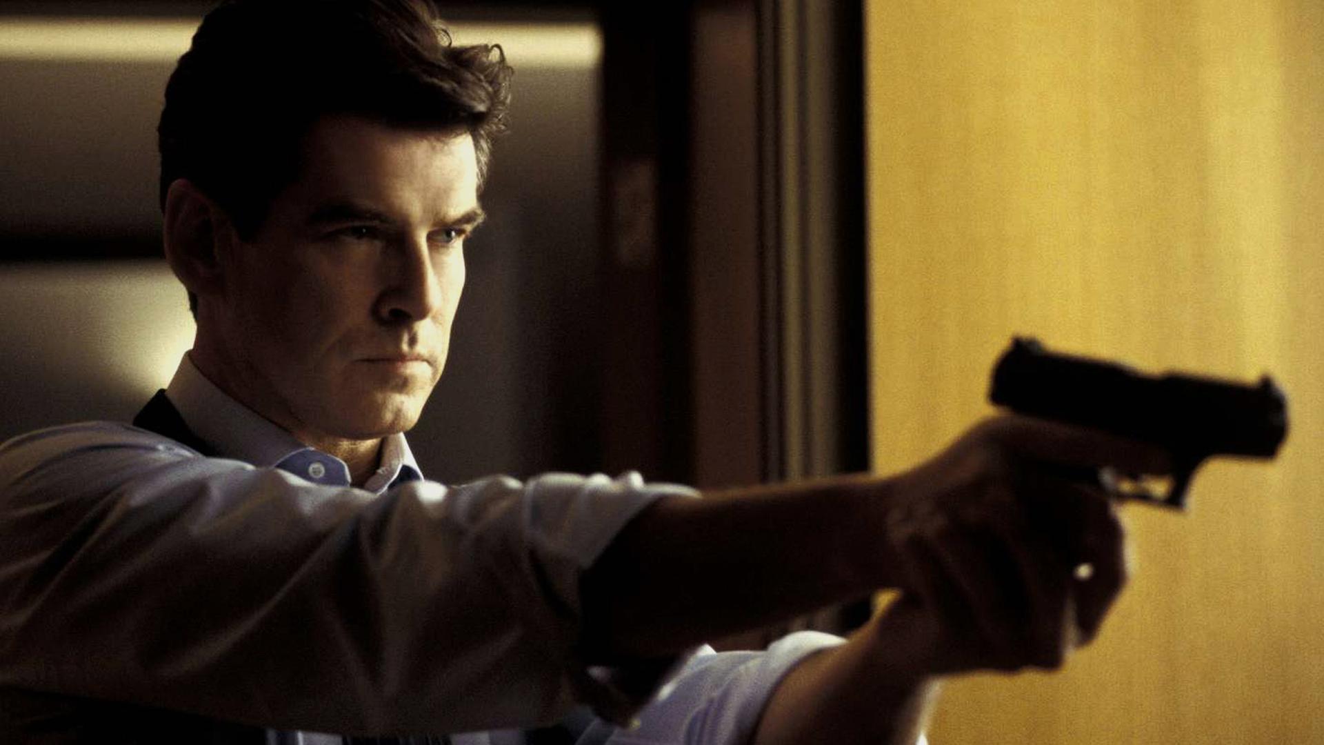 James Bond (Pierce Brosnan) in Großaufnahme mit Waffe in der Hand.