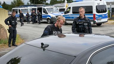 Polizisten kontrollieren auf einer Zufahrtsstraaße Autofahrer die in den Ort Stößen wollen.